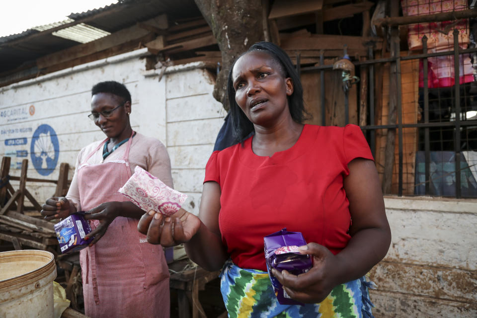 Women receive free sanitary pads in Kiambu market, Nairobi, Kenya Monday, March 6, 2023. Kenyan senator Gloria Orwoba has said that she attended parliament last month while wearing a white pantsuit stained by her menstruation in order to combat the stigma surrounding women's monthly periods. (AP Photo/Brian Inganga)