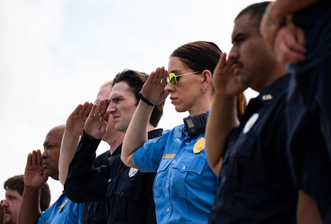 Members of the Kansas City Fire Department salute the funeral procession for North Kansas City police officer Daniel Vasquez, as it passes the by on U.S. Hwy 169, Wednesday, July 27, 2022, in Kansas City. Vasquez was shot and killed while on duty last week in North Kansas City.