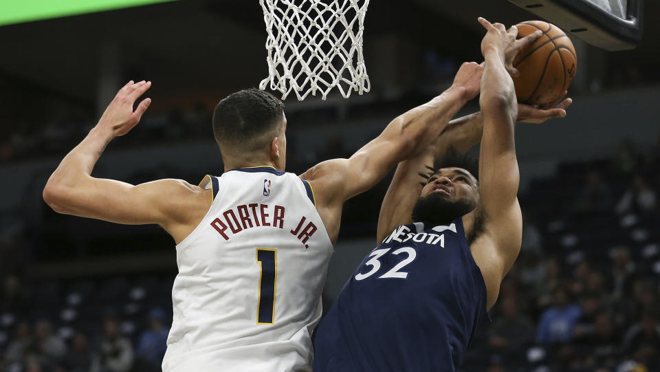 Minnesota Timberwolves' Karl-Anthony Towns is fouled by Denver Nuggets' Michael Porter Jr. in the first half of an NBA basketball game Monday, Jan. 20, 2020, in Minneapolis. (AP Photo/Stacy Bengs)