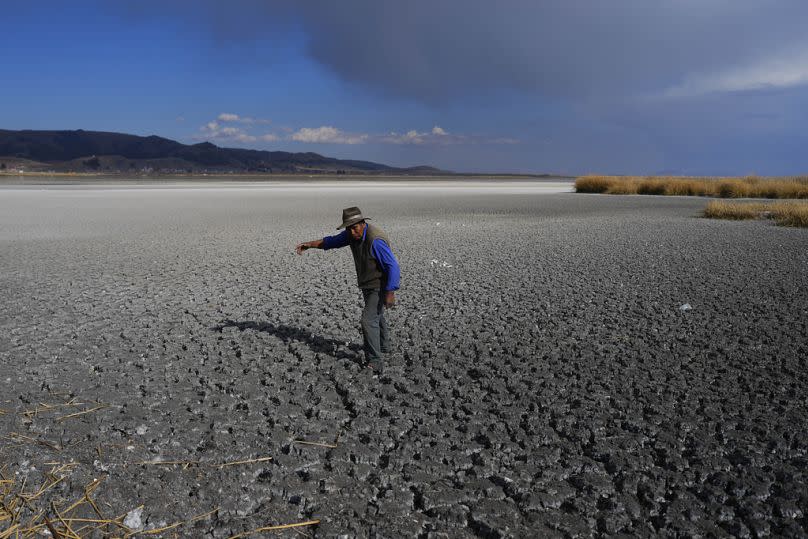 Un hombre camina sobre el lecho seco del lago Titicaca, en la Isla de Cojata, Bolivia, el 29 de septiembre de 2023.