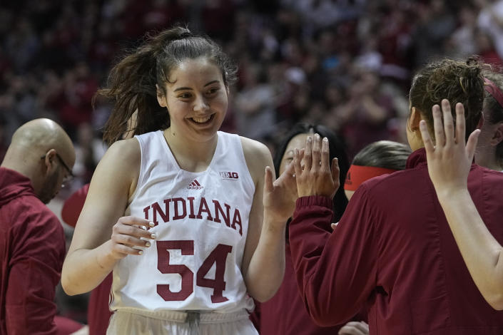 Indiana's Mackenzie Holmes (54) is greeted by teammates after being taken out of an NCAA college basketball game during the second half against Purdue, Sunday, Feb. 19, 2023, in Bloomington, Ind. (AP Photo/Darron Cummings)