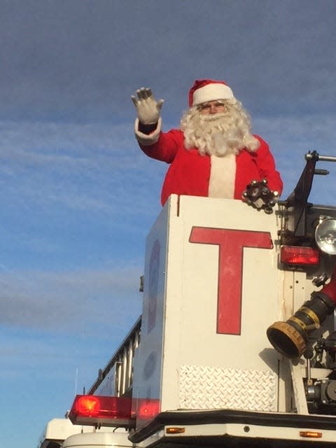 Santa waves from the top of a firetruck during a previous year's Wells Chamber parade.