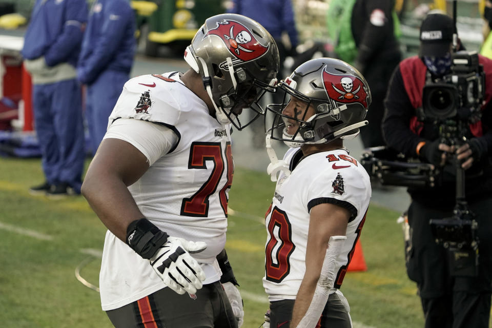 Tampa Bay Buccaneers' Scott Miller (10) celebrates his 39-yard touchdown reception with Tristan Wirfs against the Green Bay Packers during the first half of the NFC championship NFL football game in Green Bay, Wis., Sunday, Jan. 24, 2021. (AP Photo/Morry Gash)