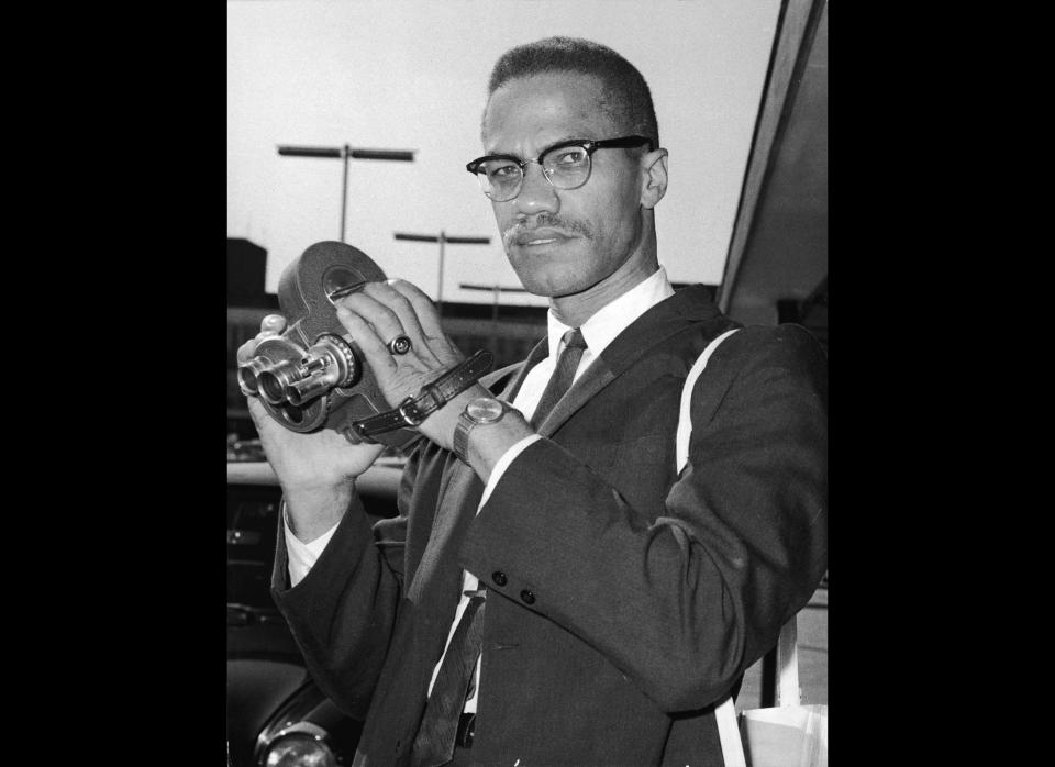 Portrait of American political activist and radical civil rights leader Malcolm X (1925 - 1965) as he holds an 8mm movie camera in London Airport, London, England, July 9, 1964.  (Express Newspapers / Getty Images)