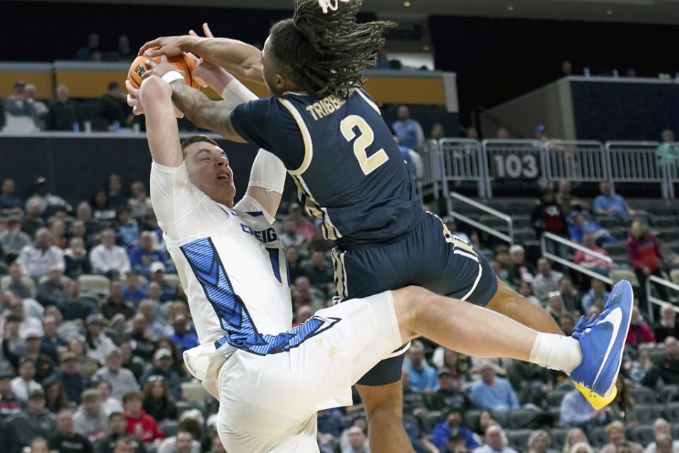 Akron’s Greg Tribble (2) fouls Creighton’s Ryan Kalkbrenner (11) during the second half of a college basketball game in the first round of the NCAA men’s tournament Thursday, March 21, 2024, in Pittsburgh. (AP Photo/Matt Freed)