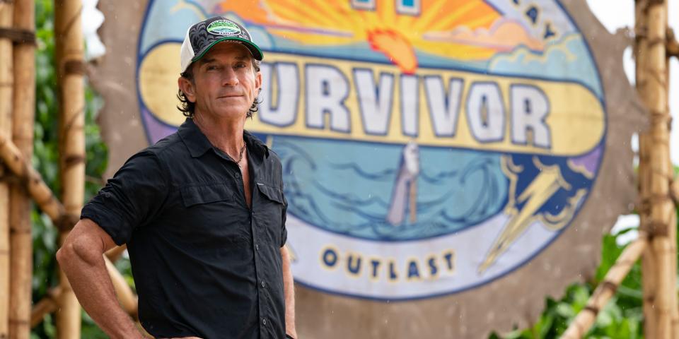 "Survivor" host Jeff Probst in front of a "Survivor" banner in 2021