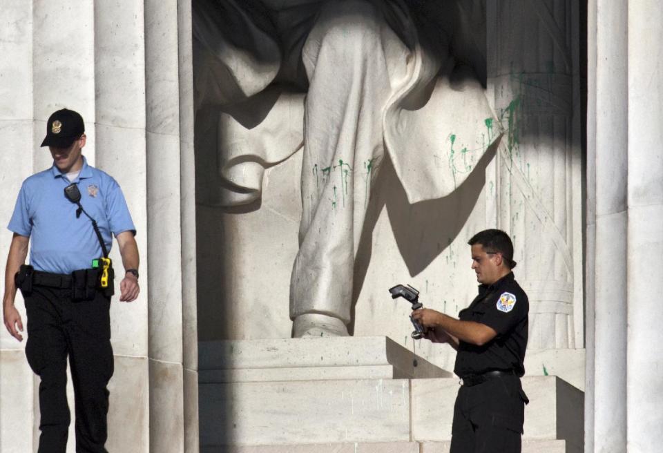 U.S. Park Police close off the Lincoln Memorial to visitors after someone splattered green paint on the statue and the floor area, in Washington, Friday, July 26, 2013. Police say the apparent vandalism was discovered early Friday morning. No words, letters or symbols were visible in the paint. (AP Photo/J. Scott Applewhite)