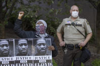 Una mujer sostiene una pancarta en la que exige justicia por la muerte de George Floyd durante una manifestación en el Centro de Gobierno de Minneapolis este 28 de mayo. (Foto: Elizabeth Flores / Star Tribune / AP).