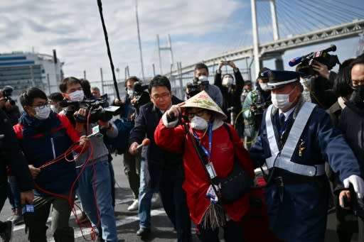 A passenger (C) from the stricken Diamond Princess leaves after a controversial 14-day quarantine on board the ship in Japan's port of Yokohama