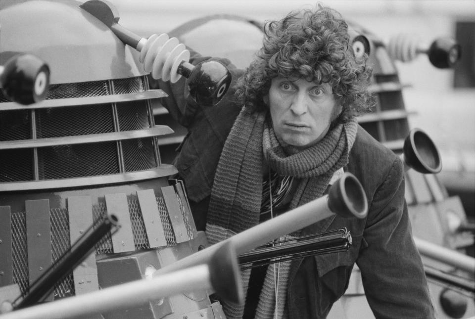 English actor Tom Baker, as the Doctor from the BBC science fiction TV series 'Doctor Who', poses with the Doctor's arch enemies, the Daleks, at BBC TV Centre, London, March 1975. Baker plays the fourth incarnation of the character. (Photo by Michael Putland/Getty Images)