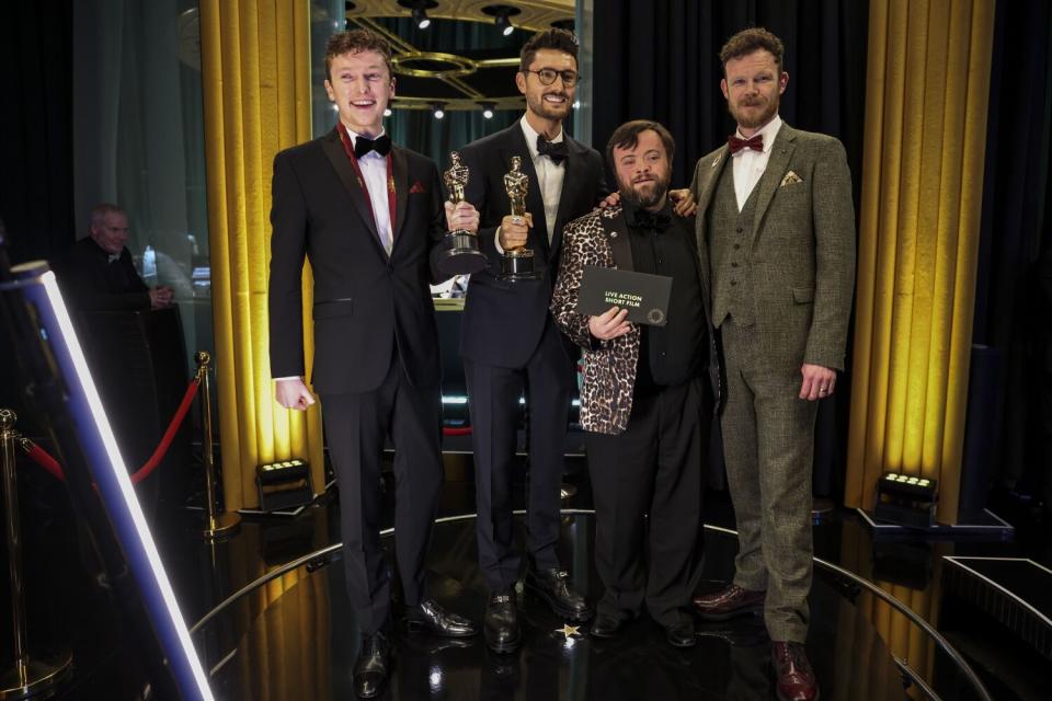 Four men in tuxes, with two holding Oscars.