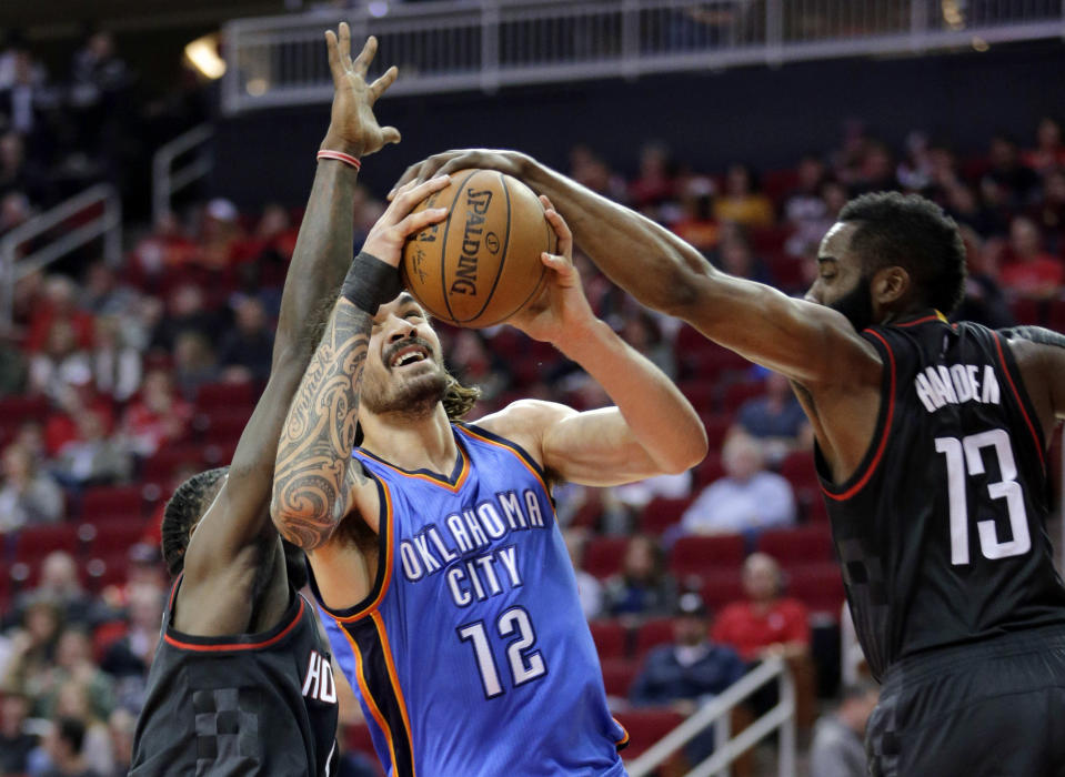 Houston Rockets Montrezl Harrell defends as Oklahoma City Thunder's Steven Adams (12) has his shot blocked by James Harden (13) in the first quarter of an NBA basketball game in Houston, Thursday Jan. 5, 2017. Thursday, Jan. 5, 2017. (AP Photo/Michael Wyke)