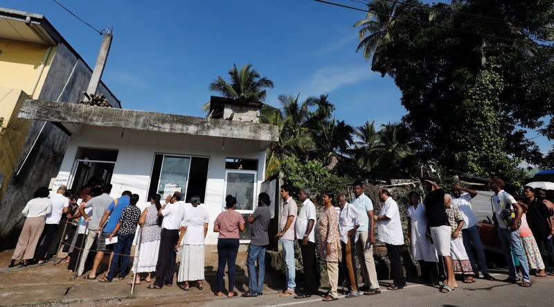 People stand in a line to cast their votes during the presidential election, at a polling station in Colombo