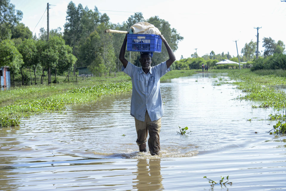 A man walks through floodwaters in Kisumu, Kenya, Wednesday, April 17, 2024. Heavy rains pounding different parts of Kenya have led to the deaths of at least 13 people and displaced some 15,000, the United Nations said, as forecasters warned more rains can be expected until June. (AP Photo/Brian Ongoro)