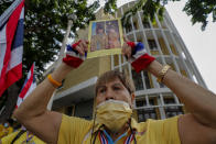 A supporter of the monarchy displays an image of King Maha Vajiralongkorn and Queen Suthida as they gather at Democracy Monument ahead of a pro-democracy demonstration in Bangkok, Thailand Sunday, Nov. 8, 2020. Thai royalists have recently been holding counterdemonstrations, but so far, they have lacked the numbers and enthusiasm of the pro-democracy activists. (AP Photo/Sakchai Lalit)