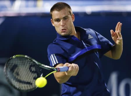 Mikhail Youzhny of Russia returns the ball to Roger Federer of Switzerland during their match at the ATP Championships tennis tournament in Dubai, February 23, 2015. REUTERS/Ahmed Jadallah