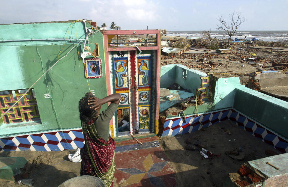 FILE - Paliyamma grieves on returning to her damaged house at a fishermen's colony hit by the tsunami, in Nagappattinam, in the southern Indian state of Tamil Nadu, Dec. 31, 2004. The huge tsunami triggered by a massive undersea earthquake in the Indian Ocean killed more than 10,000 Indians. Paliyamma lost seven members of her family. (AP Photo/Gurinder Osan, File)