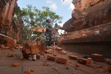 An Indonesian soldier looks at a Hindu temple damaged following an earthquake in Denpasar, Bali, Indonesia