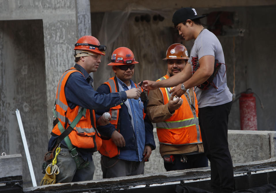 Texas Rangers outfielder Shin-Soo Choo of South Korea, right, stops to sign autographs for workers during a tour of the under construction baseball field at the new Texas Rangers stadium in Arlington, Texas, Wednesday, Dec. 4, 2019. (AP Photo/LM Otero)