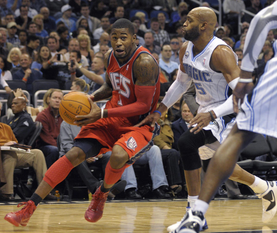 FILE - New Jersey Nets guard Terrence Williams, left, drives past Orlando Magic guard Vince Carter during the first half of an NBA basketball game in Orlando, Fla., in this Friday, Nov. 5, 2010, file photo. Eighteen former NBA players, including Williams, have been arrested on charges alleging they defrauded the league's health and welfare benefit plan out of about $4 million, according to an indictment Thursday, Oct. 7, 2021. (AP Photo/Phelan M. Ebenhack, File)