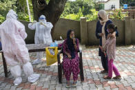 A woman and her daughter wait as their relative sits for a COVID-19 test at a rural health centre in Bagli, outskirts of Dharmsala, India, Monday, Sept. 7, 2020. India's coronavirus cases are now the second-highest in the world and only behind the United States. (AP Photo/Ashwini Bhatia)