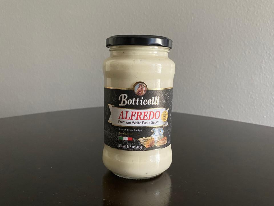 Jar of Botticelli Alfredo sauce on a black table