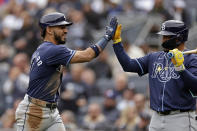 Tampa Bay Rays' José Caballero, left, high-fives Isaac Paredes after scoring on a balk during the third inning of a baseball game against the New York Yankees, Sunday, April 21, 2024, in New York. (AP Photo/Adam Hunger)