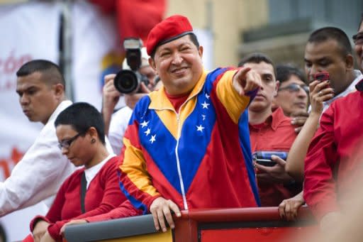 Venezuelan President Hugo Chavez (C) waves to supporters before registering his candidacy in the National Electoral Center for the upcoming presidential election, in Caracas on June 11, 2012. Thousands of followers took to the streets of Caracas supporting his candidacy