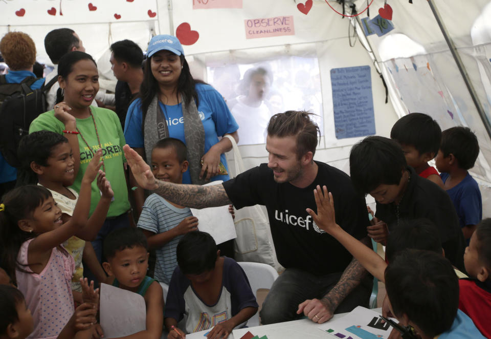 Former England soccer team captain David Beckham interacts with typhoon survivors during his visit to Typhoon Haiyan-hit Tacloban city, central Philippines, Thursday, Feb. 13, 2014. Beckham visited the storm-devastated Philippine city as part of UNICEF's relief efforts. (AP Photo/Bullit Marquez)