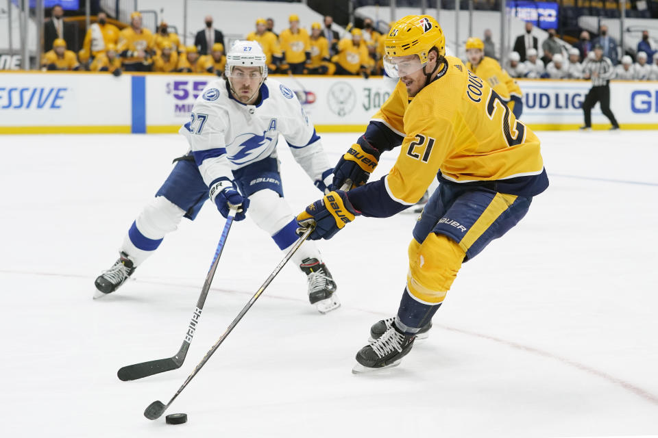 Tampa Bay Lightning's Ryan McDonagh (27) defends against Nashville Predators' Nick Cousins (21) in the second period of an NHL hockey game Saturday, April 10, 2021, in Nashville, Tenn. (AP Photo/Mark Humphrey)