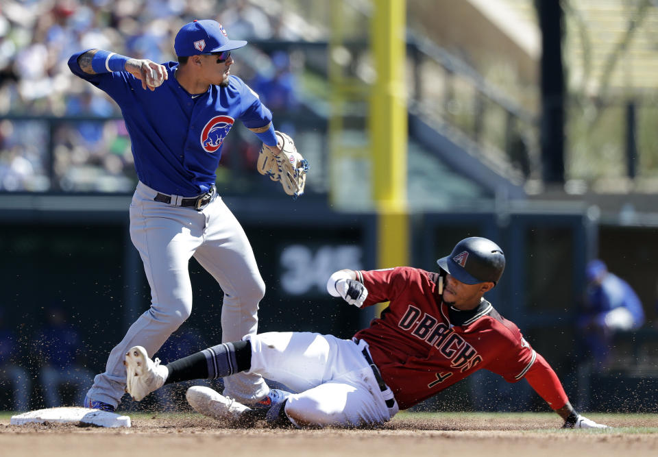 Chicago Cubs shortstop Javier Baez, left, throws to first base after forcing out Arizona Diamondbacks' Ketel Marte at second base in the first inning of a spring training baseball game Saturday, March 16, 2019, in Scottsdale, Ariz. Baez completed the double play on Diamondbacks' Carson Kelly at first. (AP Photo/Elaine Thompson)