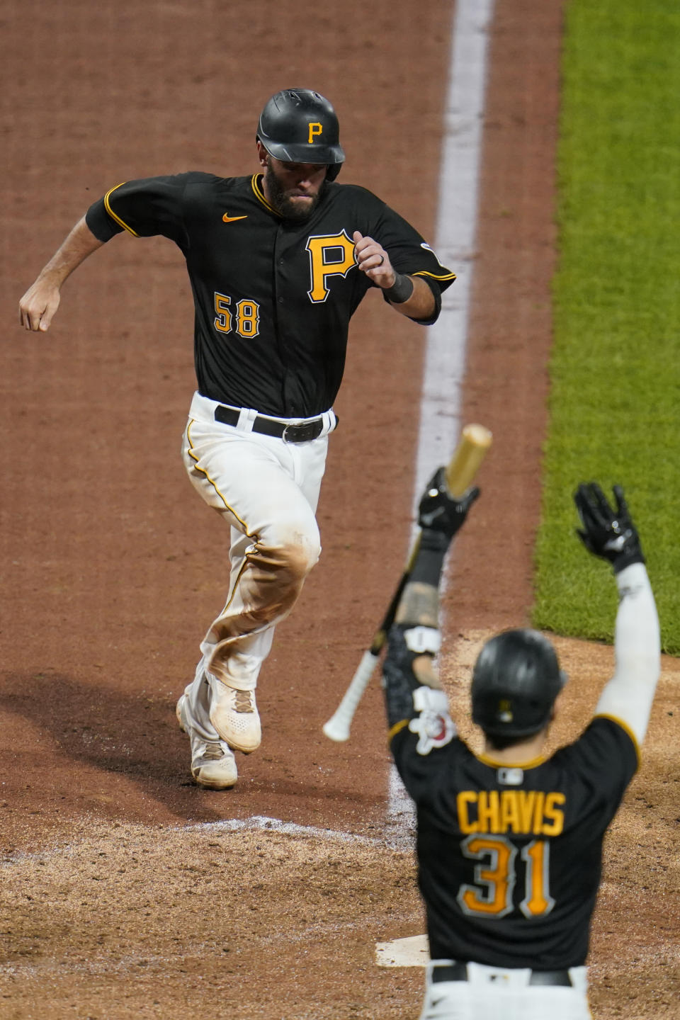 Pittsburgh Pirates' Jacob Stallings (58) scores the second of two runs on a tripe by Hoy Park off Chicago Cubs relief pitcher Adam Morgan during the sixth inning of a baseball game in Pittsburgh, Tuesday, Sept. 28, 2021. (AP Photo/Gene J. Puskar)