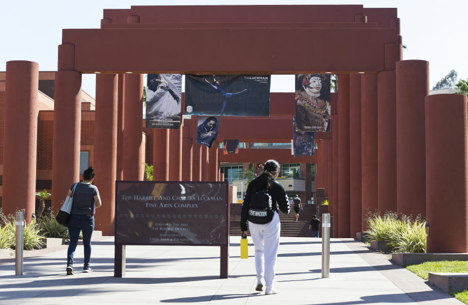 FILE - In this April 25, 2019, photo students walk past the Harriet and Charles Luckman Fine Arts Complex at the Cal State University, Los Angeles campus. Two of the nation's largest university systems say they intend to require COVID-19 vaccinations for all students, faculty and staff on University of California and California State University campuses this fall once the Food and Drug Administration gives formal approval, Thursday, April 22, 2021. (AP Photo/Damian Dovarganes, File)