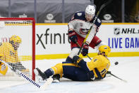 Nashville Predators defenseman Ryan Ellis (4) slides to block a shot by Columbus Blue Jackets center Pierre-Luc Dubois (18) in the first period of an NHL hockey game Saturday, Jan. 16, 2021, in Nashville, Tenn. (AP Photo/Mark Humphrey)