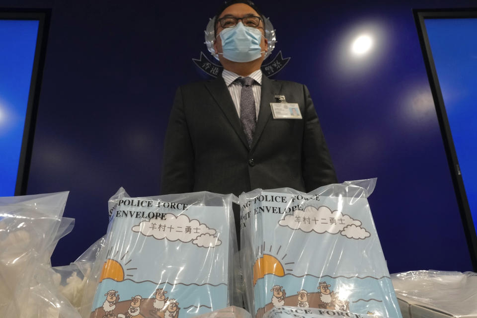 Li Kwai-wah, senior superintendent of Police National Security Department, poses in front of evidence including three children's books on stories that revolve around a village of sheep which has to deal with wolves from a different village, before a press conference in Hong Kong Thursday, July 22, 2021. Hong Kong's national security police on Thursday arrested five people from a trade union of the General Association of Hong Kong Speech Therapists on suspicion of conspiring to publish and distribute seditious material, in the latest arrests made amid a crackdown on dissent in the city. (AP Photo/Vincent Yu)