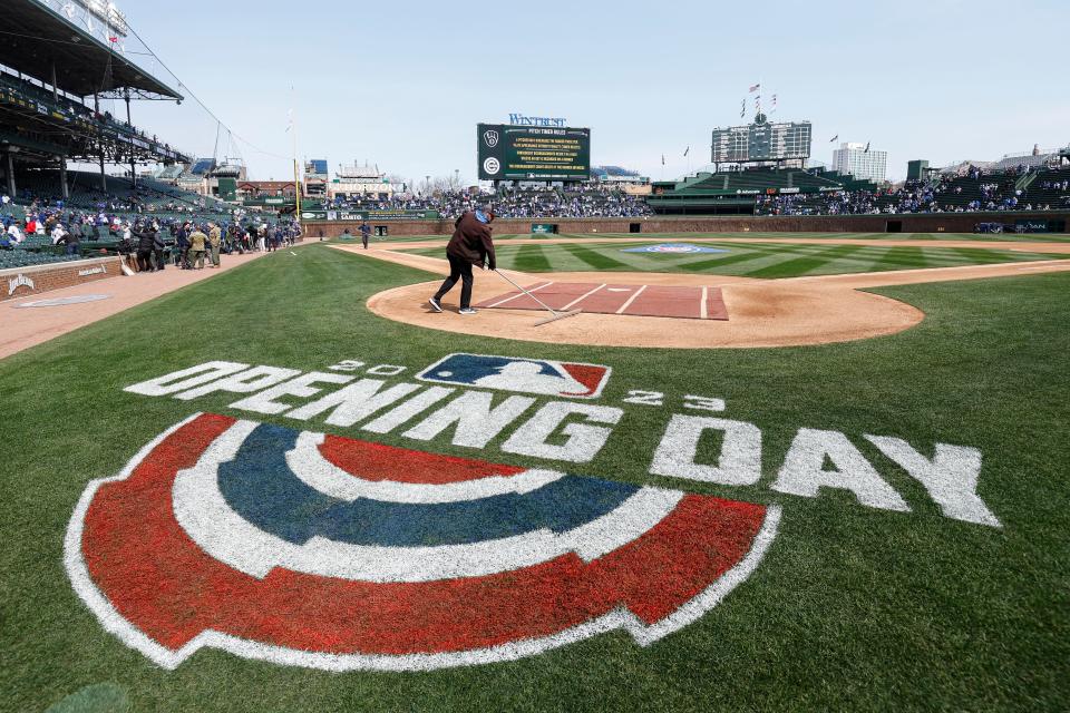 A member of the grounds crew prepares the infield before an Opening Day game between the Chicago Cubs and Milwaukee Brewers on March 30, 2023.