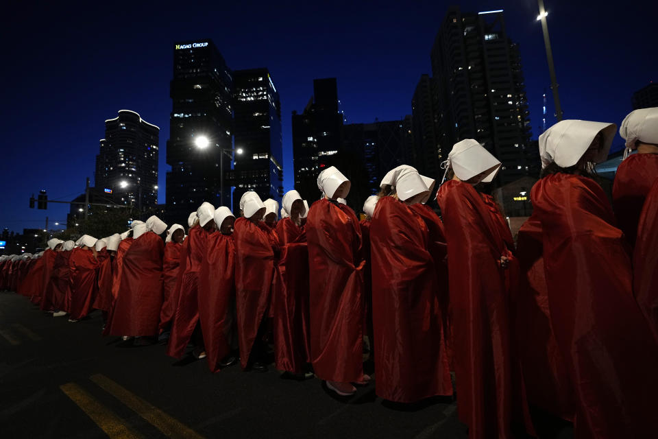 File - Israeli women's rights activists dressed as characters in the popular television series, "The Handmaid's Tale," protest plans by Prime Minister Benjamin Netanyahu's government to overhaul the judicial system, in Tel Aviv, Israel, Saturday, March 11, 2023. (AP Photo/Ohad Zwigenberg, File)
