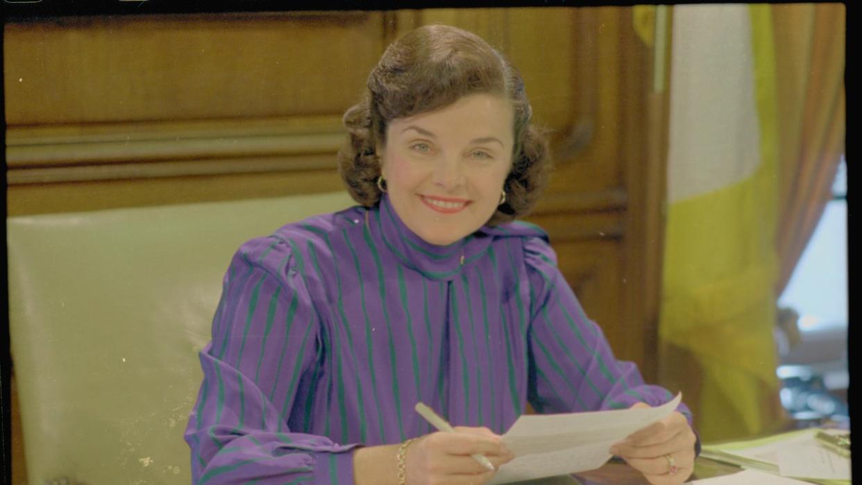 <div>San Franciscos mayor Dianne Feinstein smiling and reviewing a document in her city hall office. (Getty Images)</div>