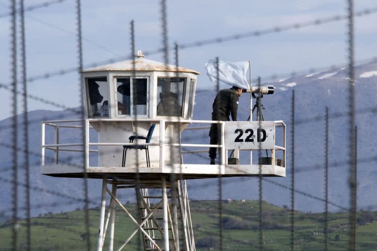 A UN peacekeeper is seen on an observation tower in the largely abandoned city of Quneitra, in the demilitarized United Nations Disengagement Observer Force (UNDOF) zone, in the Golan Heights, on March 8, 2013. A group of 21 UN peacekeepers seized by Syrian rebels on the Golan were still being held on Saturday after a two-hour truce during which their release had been expected, a watchdog said