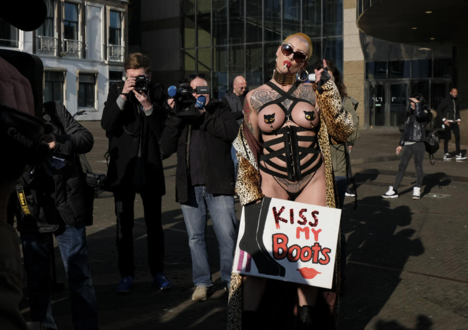 Sex workers carry signs protesting unequal treatment and stigmatizing during a demonstration in The Hague, Netherlands, Tuesday, March 2, 2021. Stores in one village opened briefly, cafe owners across the Netherlands were putting tables and chairs on their outdoor terraces and sex workers demonstrated outside parliament in protests against the government's tough coronavirus lockdown. (AP Photo/Patrick Post)