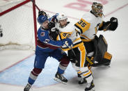 Colorado Avalanche center Darren Helm, front left, is moved out from in front of the net by Pittsburgh Penguins defenseman Mark Friedman, front right, as goaltender Tristan Jarry looks for a shot in the first period of an NHL hockey game Saturday, April 2, 2022, in Denver. (AP Photo/David Zalubowski)