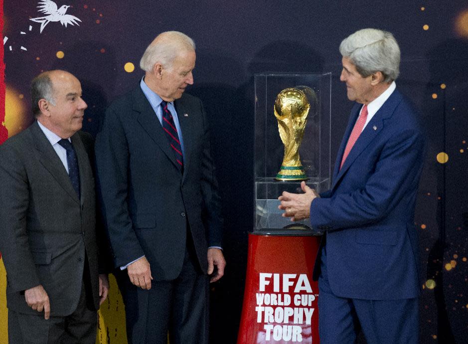 From left, Brazil's Ambassador to the US Mauro L.I. Vieira, Vice President Joe Biden, and Secretary of State John Kerry, look at the FIFA World Cup trophy, the actual trophy that will be awarded to the winner of this year’s World Cup soccer tournament in Brazil, Monday, April 14,2014, during an unveiling ceremony at the State Department in Washington. (AP Photo/Manuel Balce Ceneta)