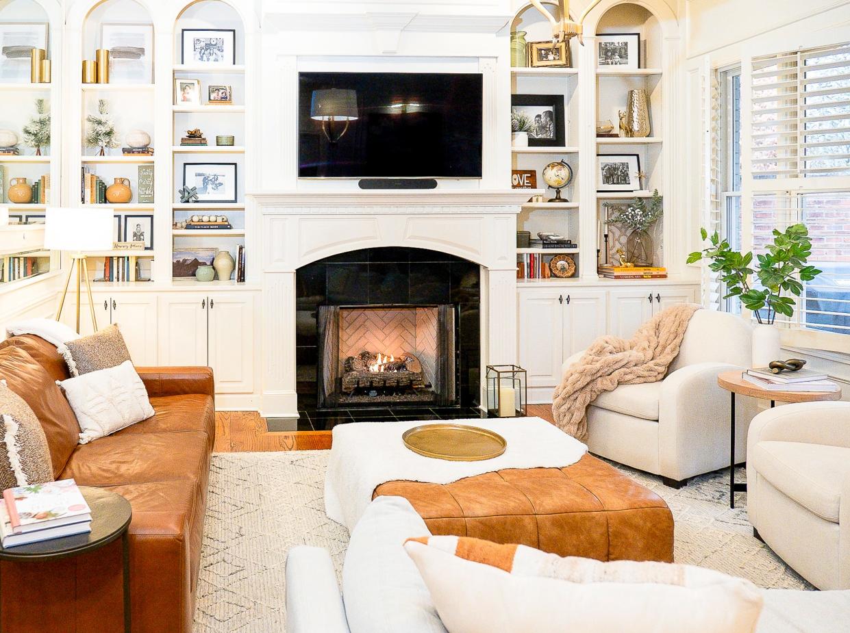 The living room is a very cozy space with plenty of storage, a working fireplace, and plenty of comfortable furniture.