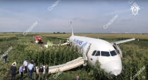 In this file image taken from a video distributed by Russian Investigative Committee, Investigative Committee employees works at a crash site of a Russian Ural Airlines' A321 plane is seen after an emergency landing in a cornfield near Ramenskoye, outside Moscow, Russia, Thursday, Aug. 15, 2019. The Russian pilot was being hailed as a hero Thursday for safely landing his passenger jet in a corn field after it collided with a flock of gulls seconds after takeoff, causing both engines to malfunction. While dozens of people on the plane sought medical assistance, only one was hospitalized. (The Investigative Committee of the Russian Federation via AP) EDS NOTE: Watermark placed on image at source translated as InvestCom