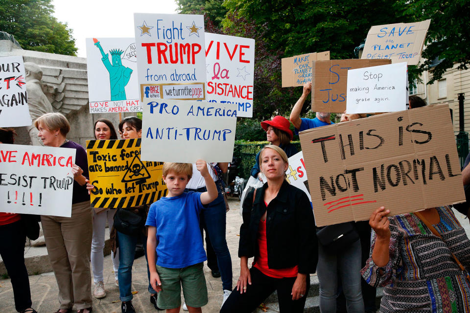 <p>Protesters hold a placard reading ‘Pro America – Anti-Trump’ as they gather at the Memorial to the American volunteers at the Place des Etats-Unis in Paris, on July 13, 2017, to demonstrate against the visit of President Donald Trump. (Photo: Geoffroy Van Der Hasselt/AFP/Getty Images) </p>