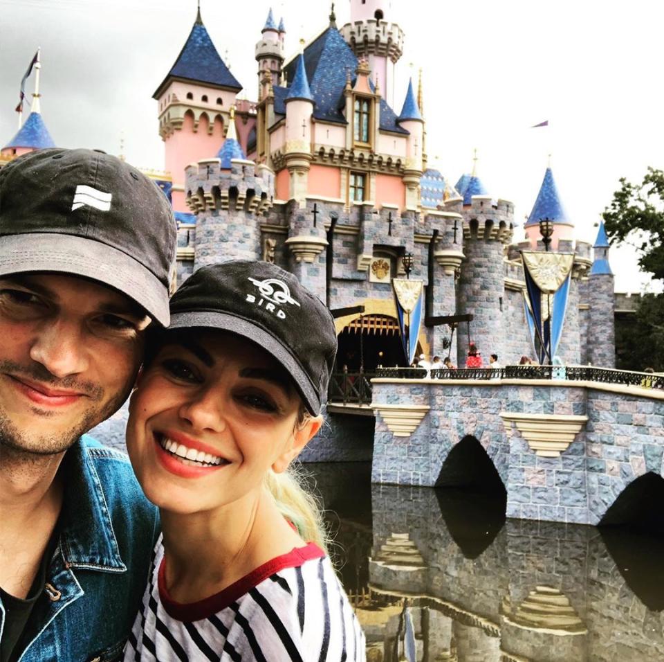 Mila Kunis and Ashton Kutcher pose at Disneyland