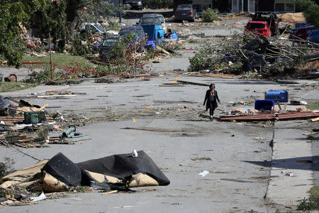 A woman walks past debris after a tornado hit the Mont-Bleu neighbourhood in Gatineau, Quebec, Canada, September 22, 2018. REUTERS/Chris Wattie