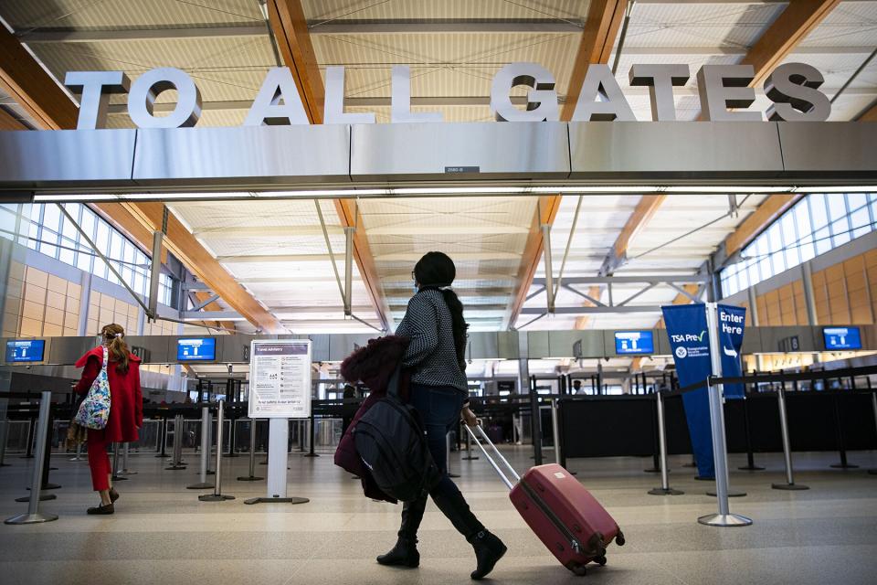 A traveler carries luggage while walking through terminal 2 at Raleigh-Durham International Airport (RDU) in Morrisville, North Carolina,