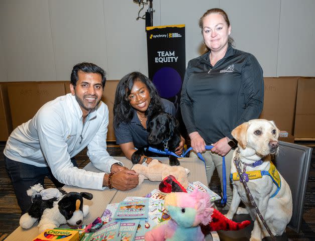 <p>Synchrony</p> Synchrony encourages team members to give back to their communities. Here, Synchrony volunteers Furqan Haq (left) and Gabrielle Jeannot (center), with Canine Companions’ Christina Canter (right), engage with future service dogs in Chicago in May.