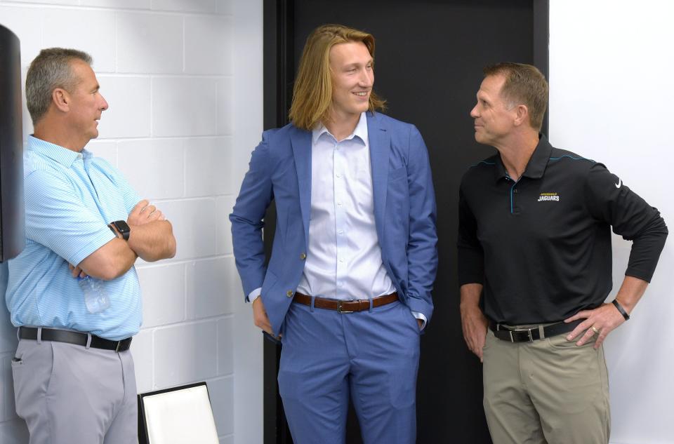 Jacksonville Jaguars head coach Urban Meyer, left, and general manager Trent Baalke talk with the team's first-round draft pick Trevor Lawrence before the start of Friday afternoon's press conference.